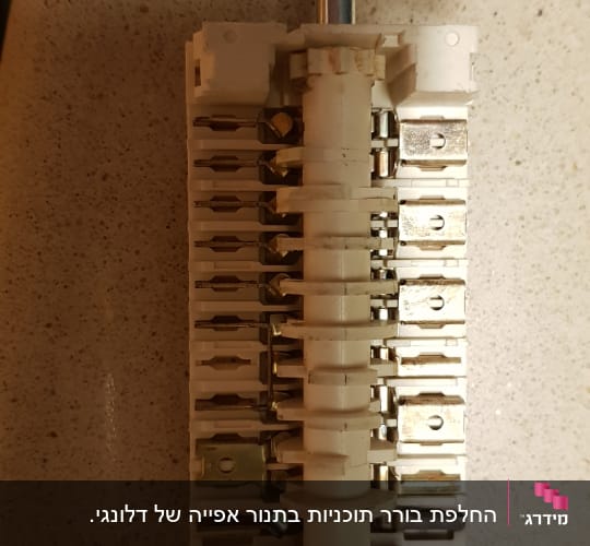 מתג חשמלי עם חיבורים מתכתיים על משטח בהיר